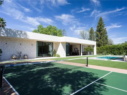 a view of a house with backyard and sitting area