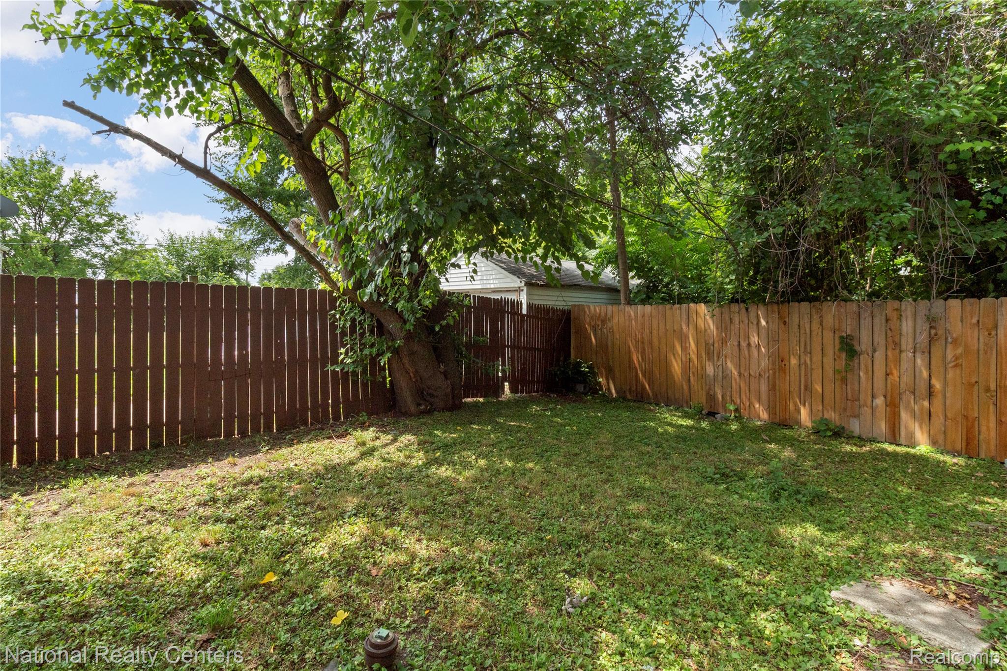 13525 Evergreen Road Detroit, MI 48223 - Photo 23 of 25 Expansive backyard featuring a combination wood privacy fence, mature trees, and a grassy area