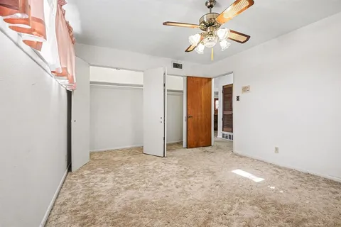 a view of an empty room with a ceiling fan