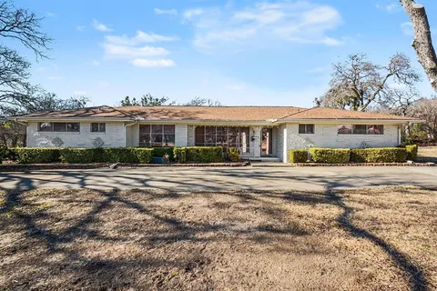 a view of a white house with a large swimming pool and outdoor seating