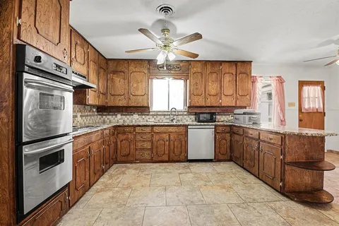 a kitchen with stainless steel appliances granite countertop a stove sink and cabinets