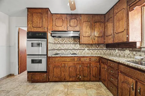 a kitchen with granite countertop stainless steel appliances and cabinets