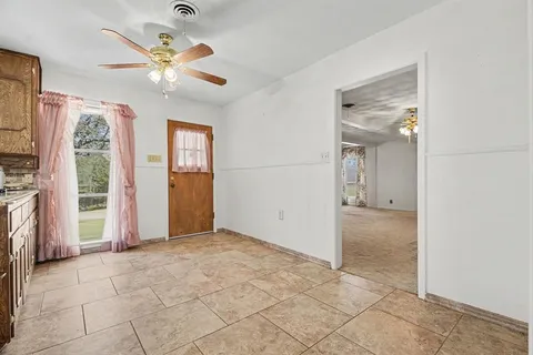 an empty room with fan and windows