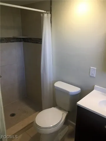 a white toilet sitting next to a shower