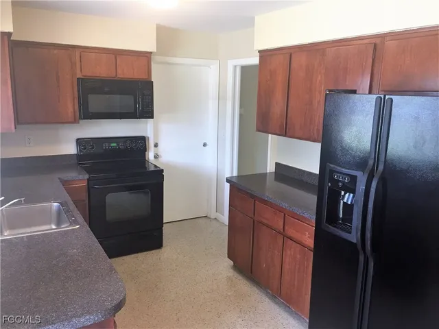 a kitchen with stainless steel appliances wooden cabinets and a refrigerator
