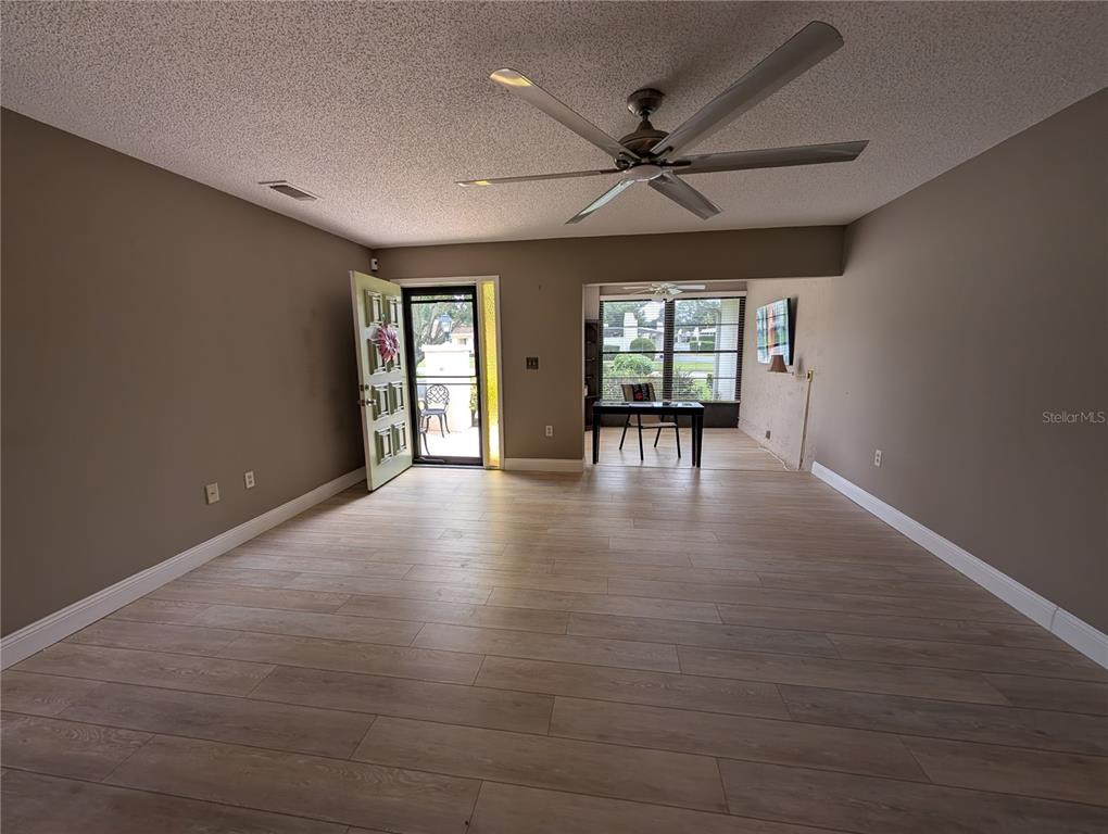 8161 Braddock Circle, Unit 1 Port Richey, FL 34668 - Photo 7 of 27 an empty room with wooden floor and windows