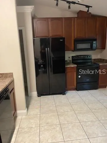 a kitchen with stainless steel appliances granite countertop a refrigerator and a microwave