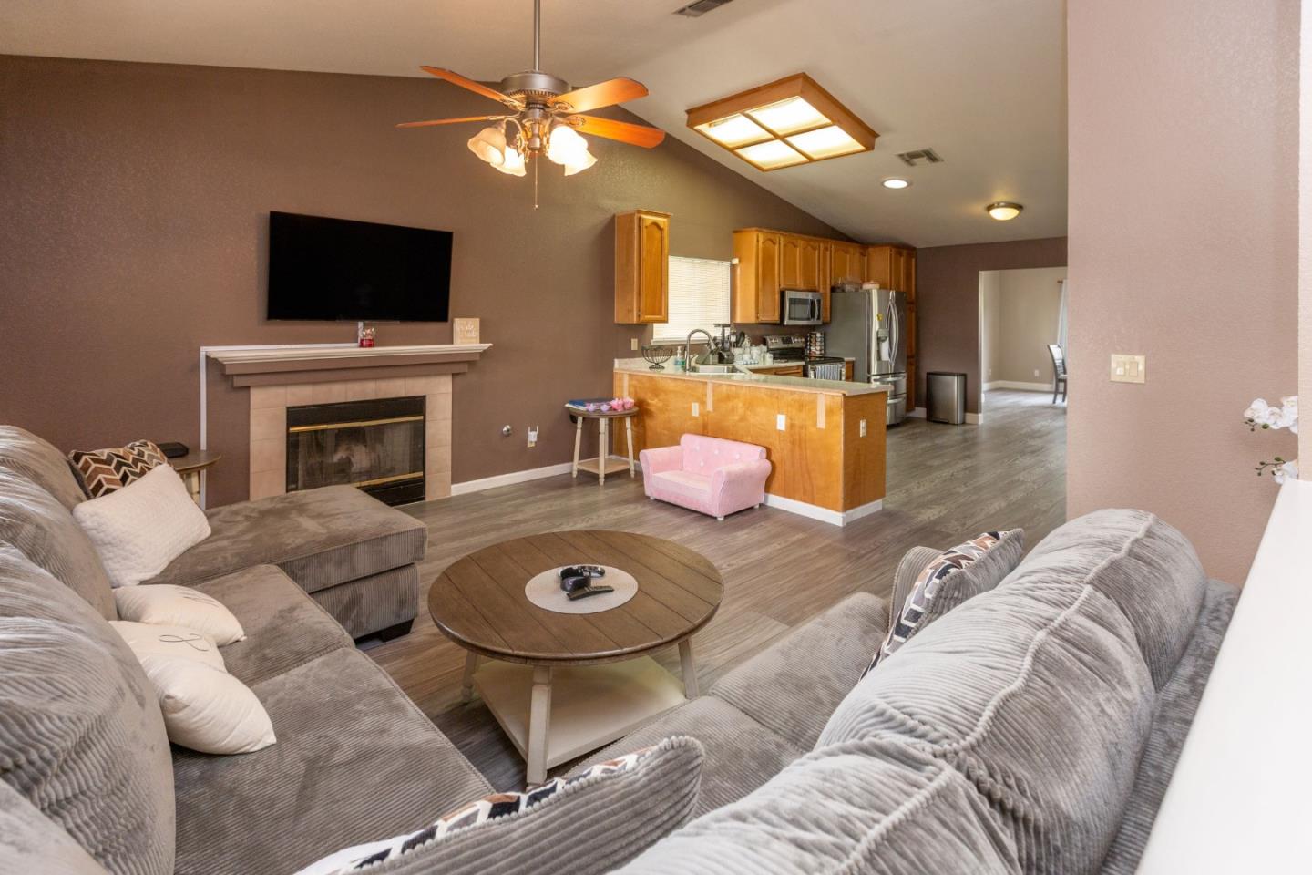 2085 Roth Court Turlock, CA 95380 - Photo 4 of 26 a living room with furniture a fireplace and a flat screen tv