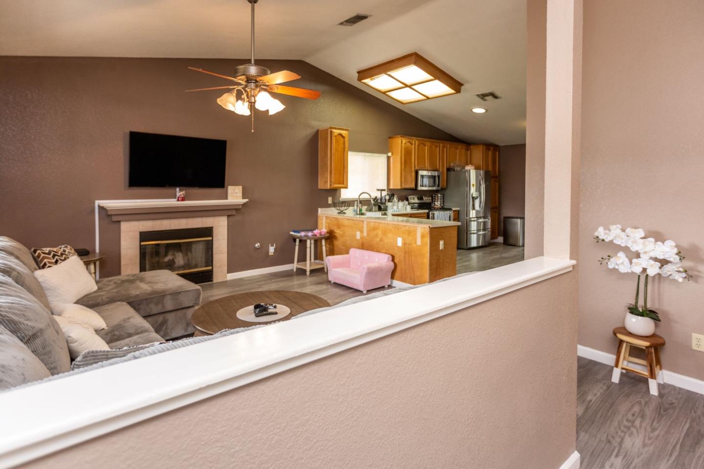 2085 Roth Court Turlock, CA 95380 - Photo 8 of 26 a living room with furniture a flat screen tv and a fireplace