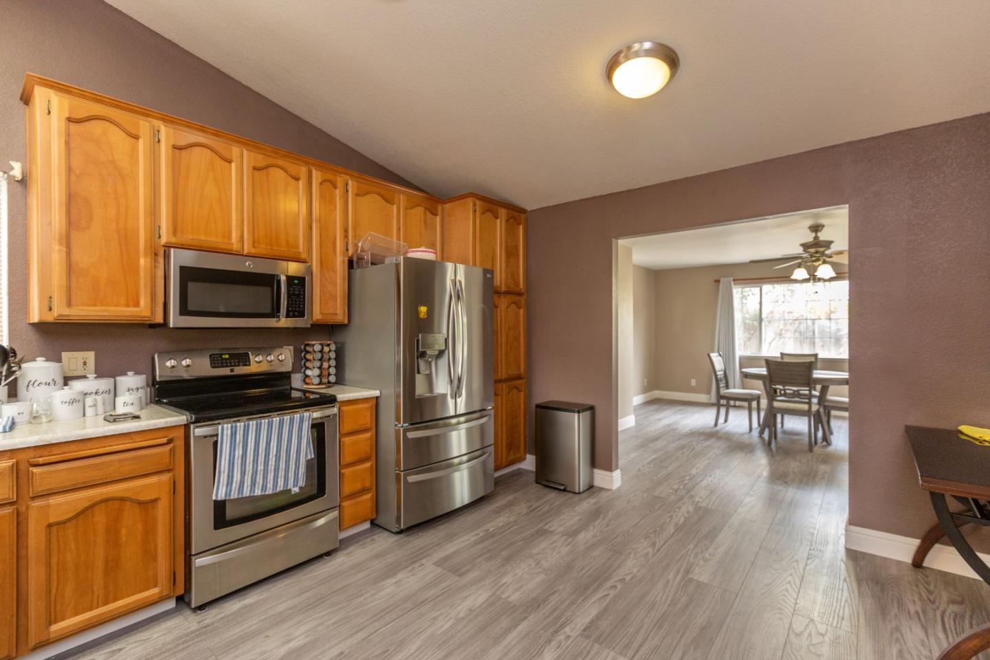 2085 Roth Court Turlock, CA 95380 - Photo 9 of 26 a kitchen with stainless steel appliances wooden floors and wooden cabinets