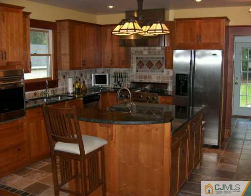 631 Ridge Road Monmouth Junction, NJ 08852 - Photo 2 of 8 a kitchen with stainless steel appliances granite countertop a sink refrigerator and cabinets