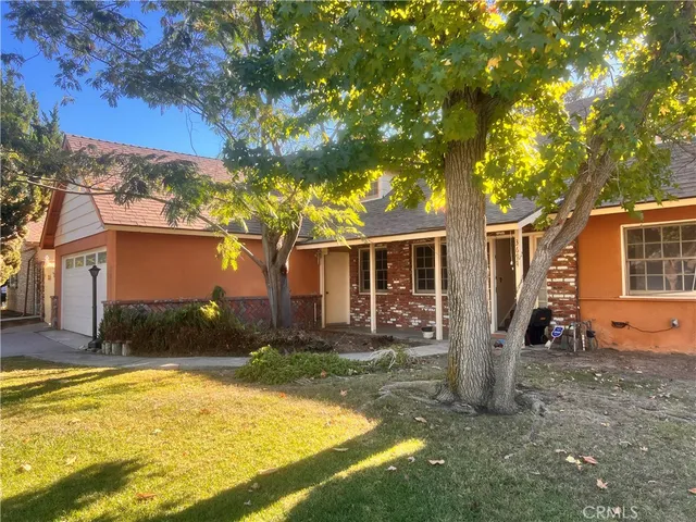 a front view of house with yard and trees in the background