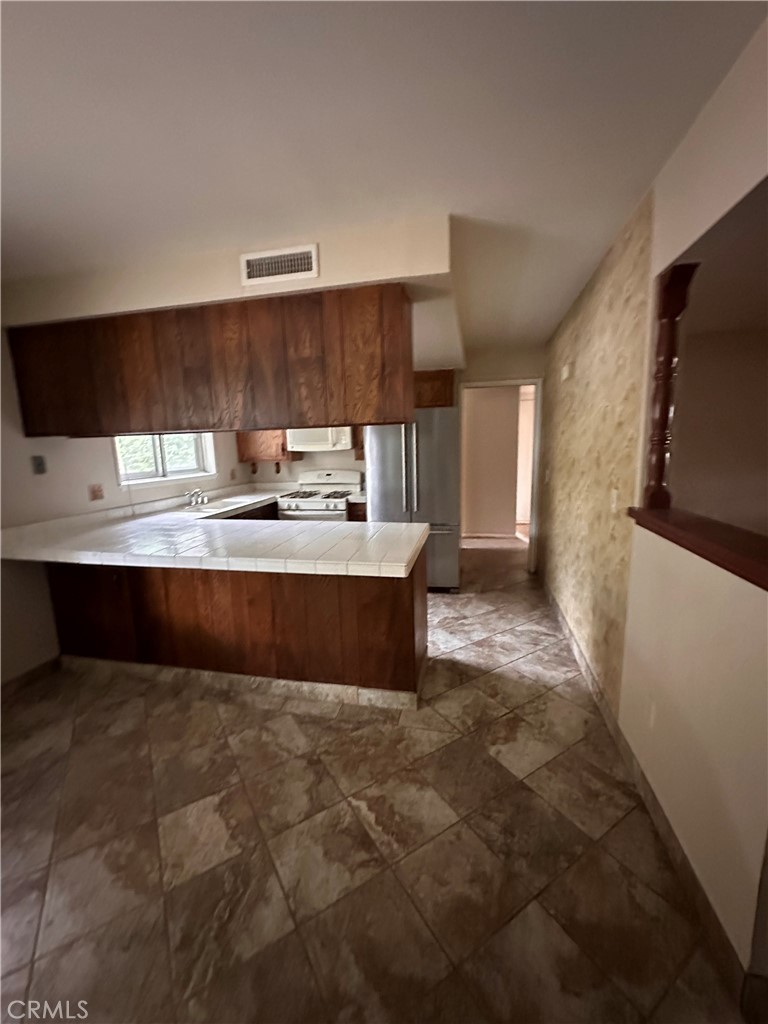 3694 Gay Way Riverside, CA 92504 - Photo 6 of 26 a large kitchen with kitchen island granite countertop a sink and a stove
