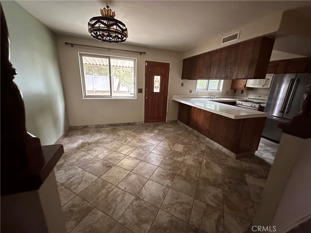 3694 Gay Way Riverside, CA 92504 - Photo 7 of 26 a kitchen with granite countertop a stove a sink and a refrigerator