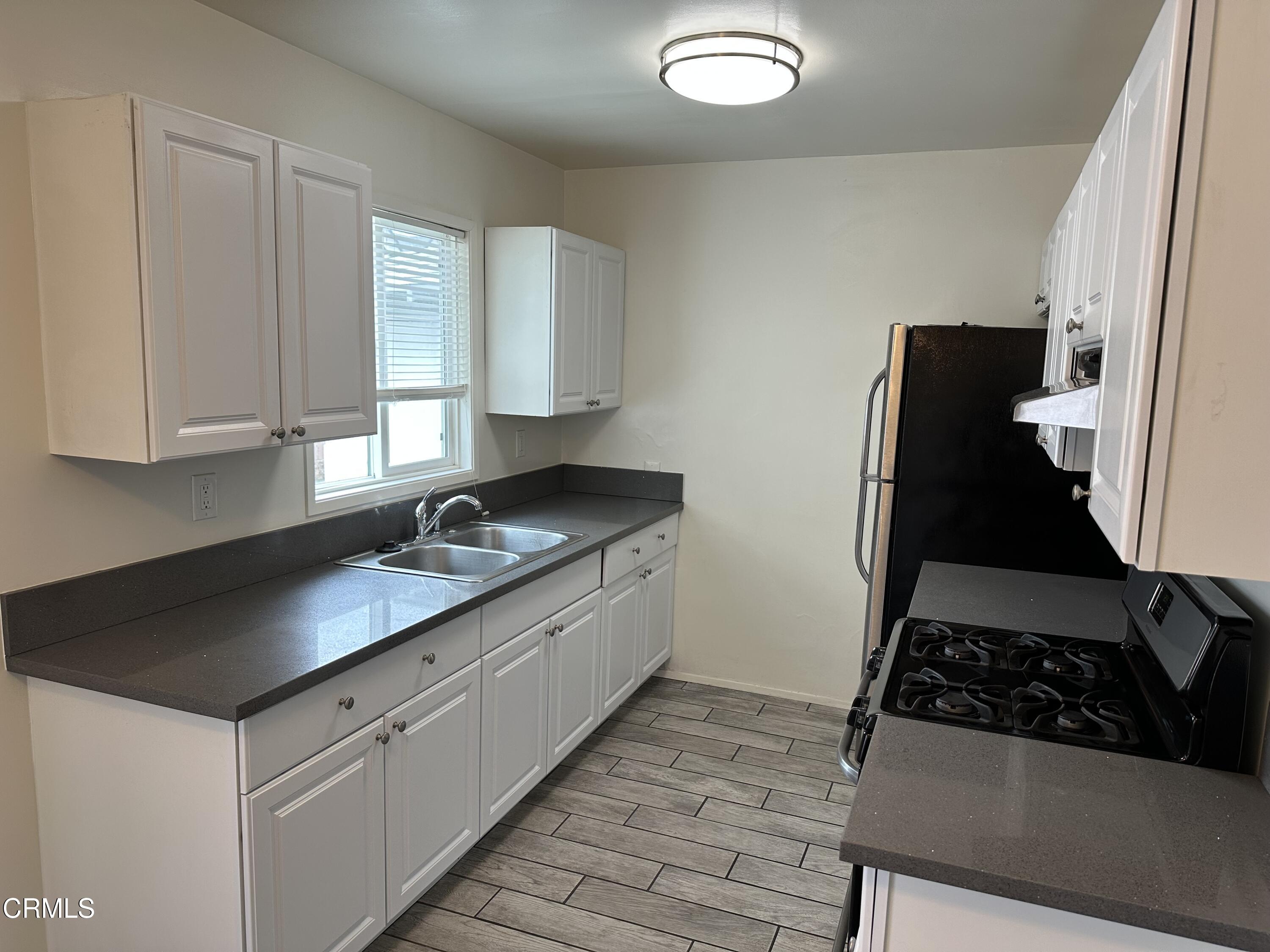 1148 Spazier Avenue, Unit B Glendale, CA 91201 - Photo 14 of 31 a kitchen with granite countertop white cabinets and black appliances