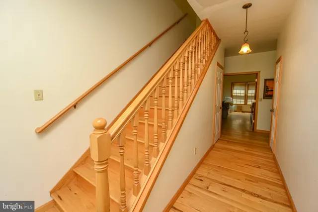a view of a hallway with wooden floor and staircase