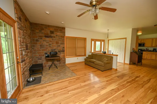 a dining room with wooden floor a chandelier a wooden table and chairs