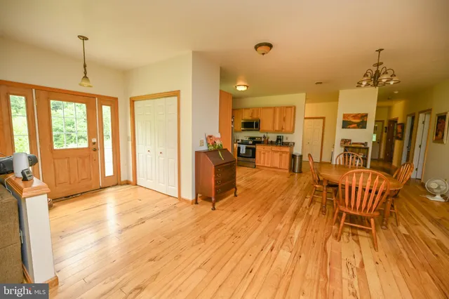 a dining room with wooden floor and chandelier
