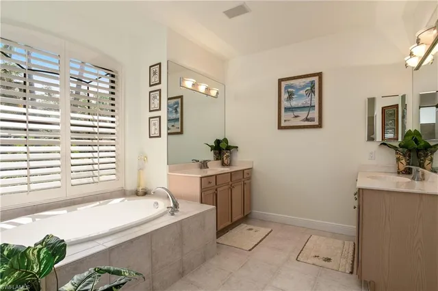 a bathroom with a tub sink and mirror