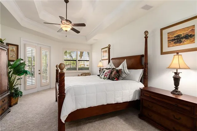 a bedroom with a bed and potted plant on the dresser