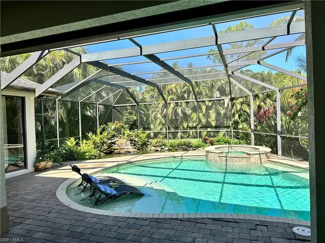 a view of a swimming pool with a yard and plants