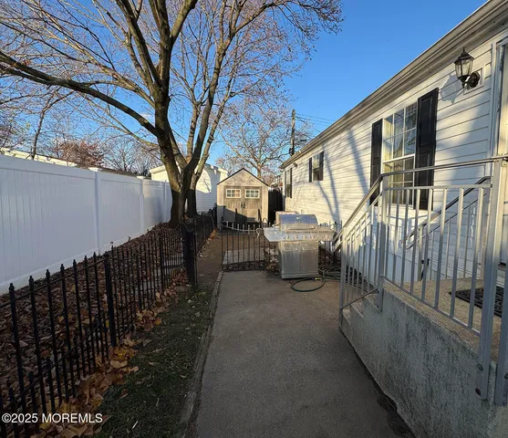 a view of a patio with table and chairs and wooden fence