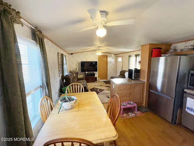 a dining room with furniture a large window and stainless steel appliances