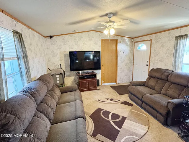 a living room with furniture a flat screen tv and a large window