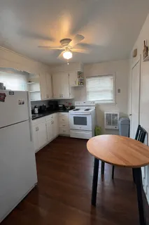 a kitchen with a table chairs refrigerator and cabinets
