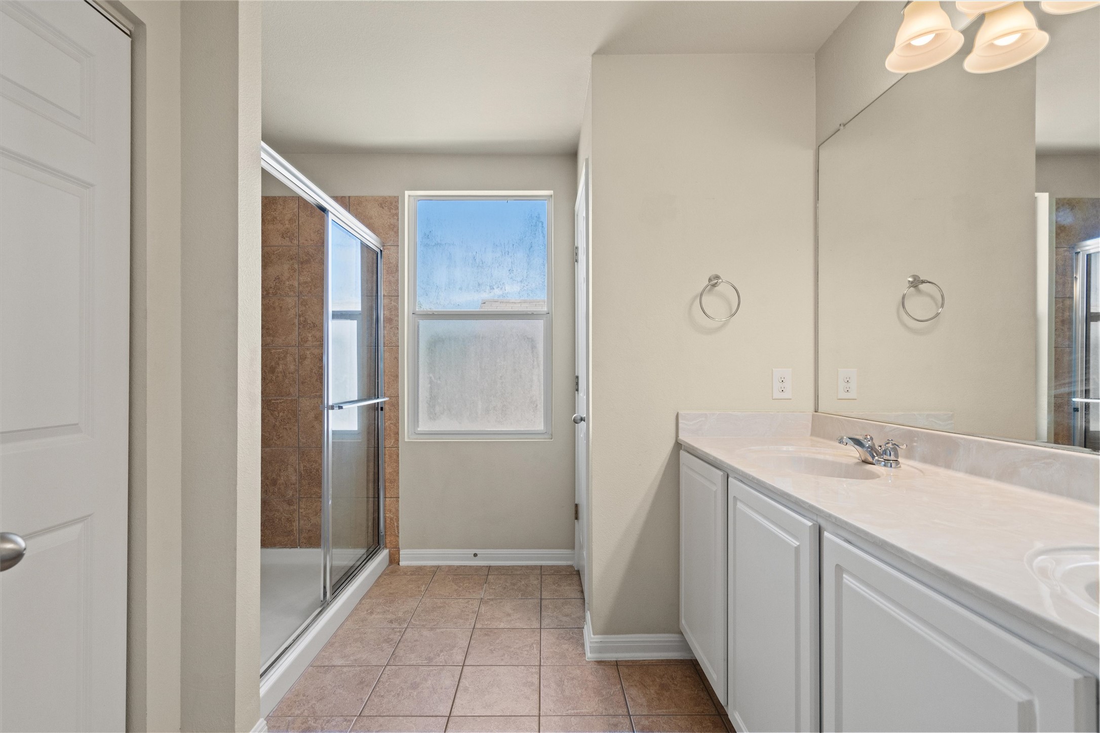 423 Wetzel Kyle, TX 78640 - Photo 24 of 35 Full bathroom with a stall shower, double vanity, and light tile patterned floors