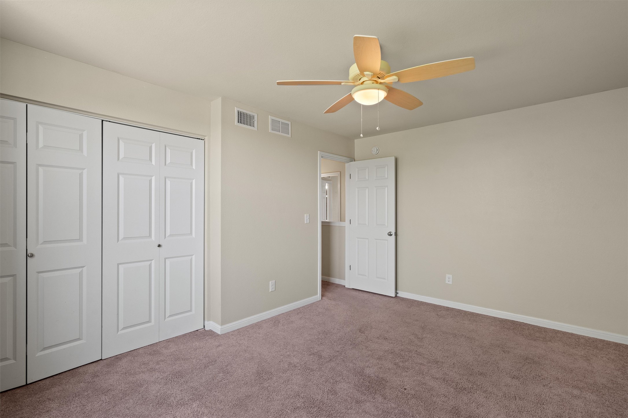 423 Wetzel Kyle, TX 78640 - Photo 26 of 35 Unfurnished bedroom with light colored carpet, a ceiling fan, and a closet