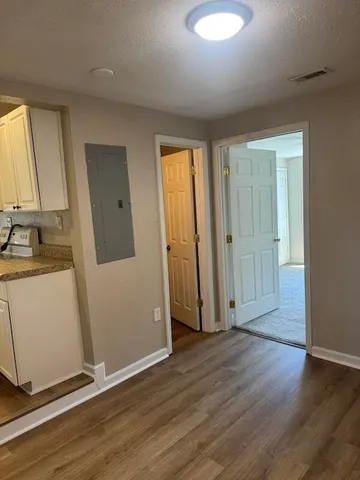 an empty room with wooden floor and windows