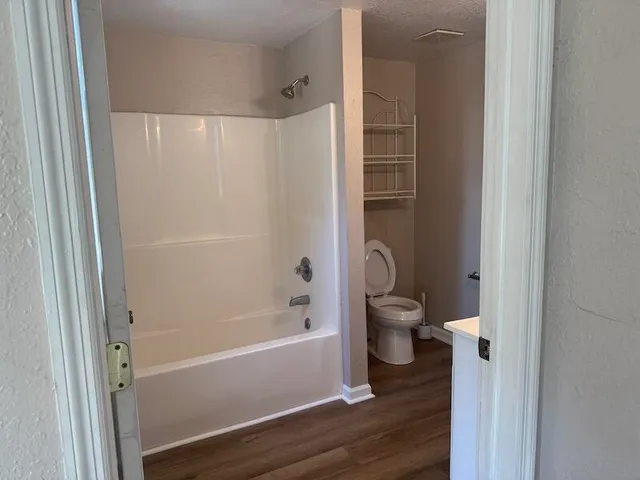 a bathroom with a granite countertop tub toilet and a shower
