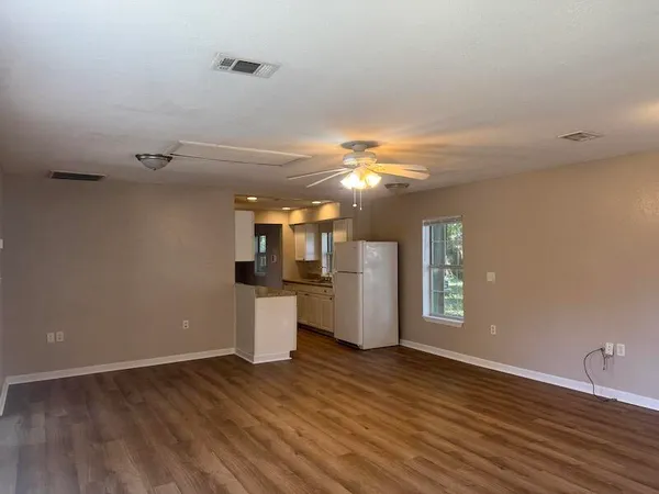 a view of a kitchen with wooden floor and electronic appliances