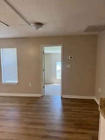 a view of an empty room with wooden floor