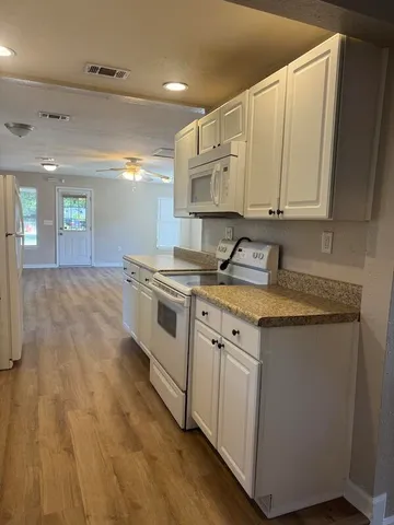 a kitchen with granite countertop a sink a stove and cabinets