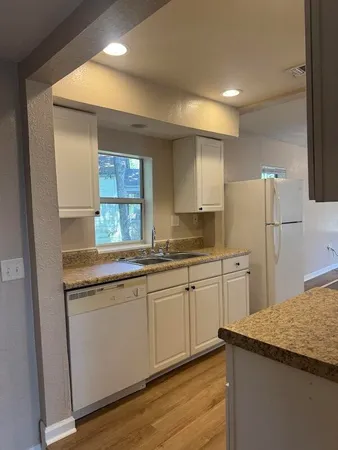 a kitchen with granite countertop a sink and a refrigerator