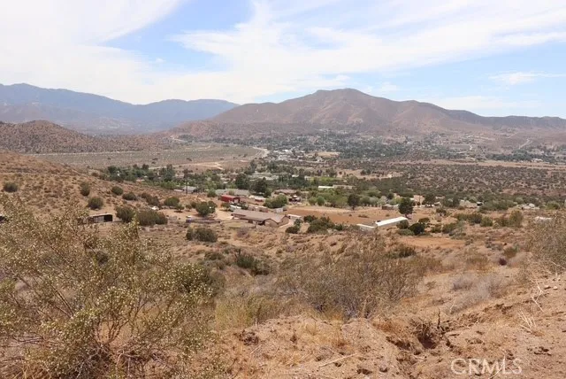 a view of a dry yard with mountains in the background