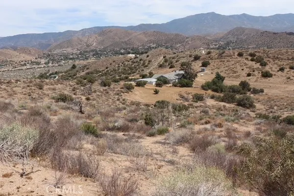 a view of a lush green hillside and houses