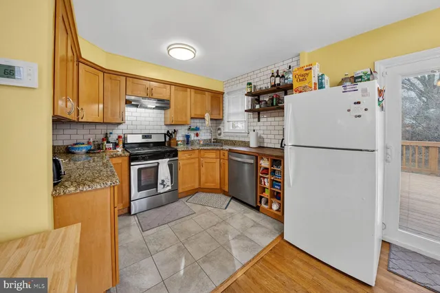 a kitchen with stainless steel appliances granite countertop a refrigerator a stove a sink and a microwave