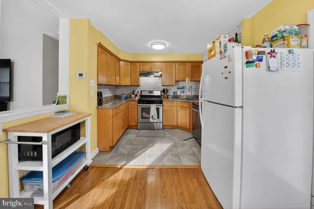 a kitchen with wooden cabinets and stainless steel appliances