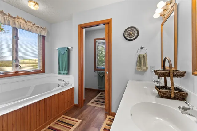 a bathroom with a tub a sink and a large mirror