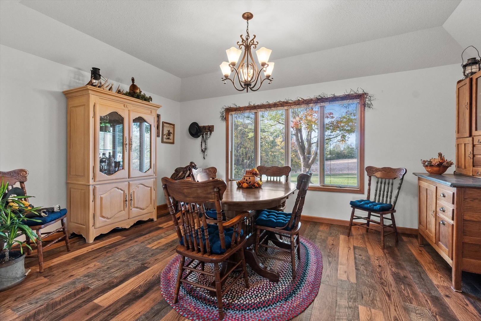 15344 Norrish Road Morrison, IL 61270 - Photo 8 of 50 a dining room with wooden floor a chandelier a wooden table and chairs