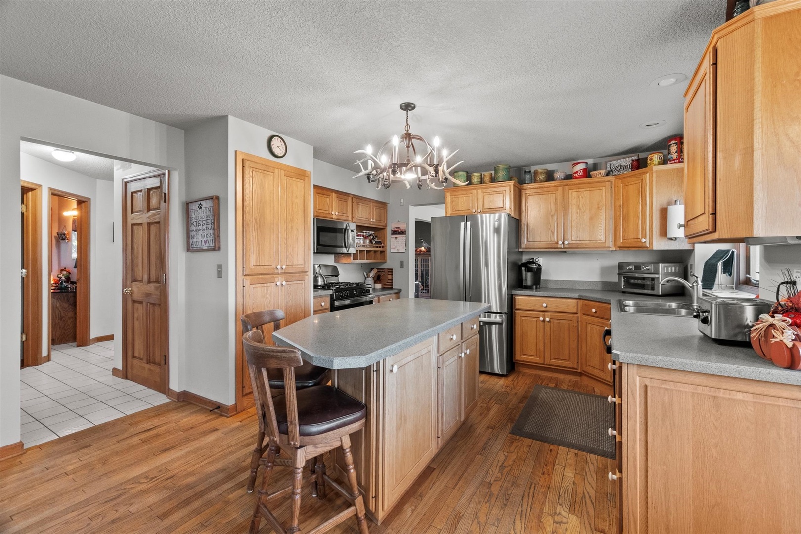 15344 Norrish Road Morrison, IL 61270 - Photo 9 of 50 a kitchen with granite countertop a refrigerator a stove a sink a dining table and chairs with wooden floor