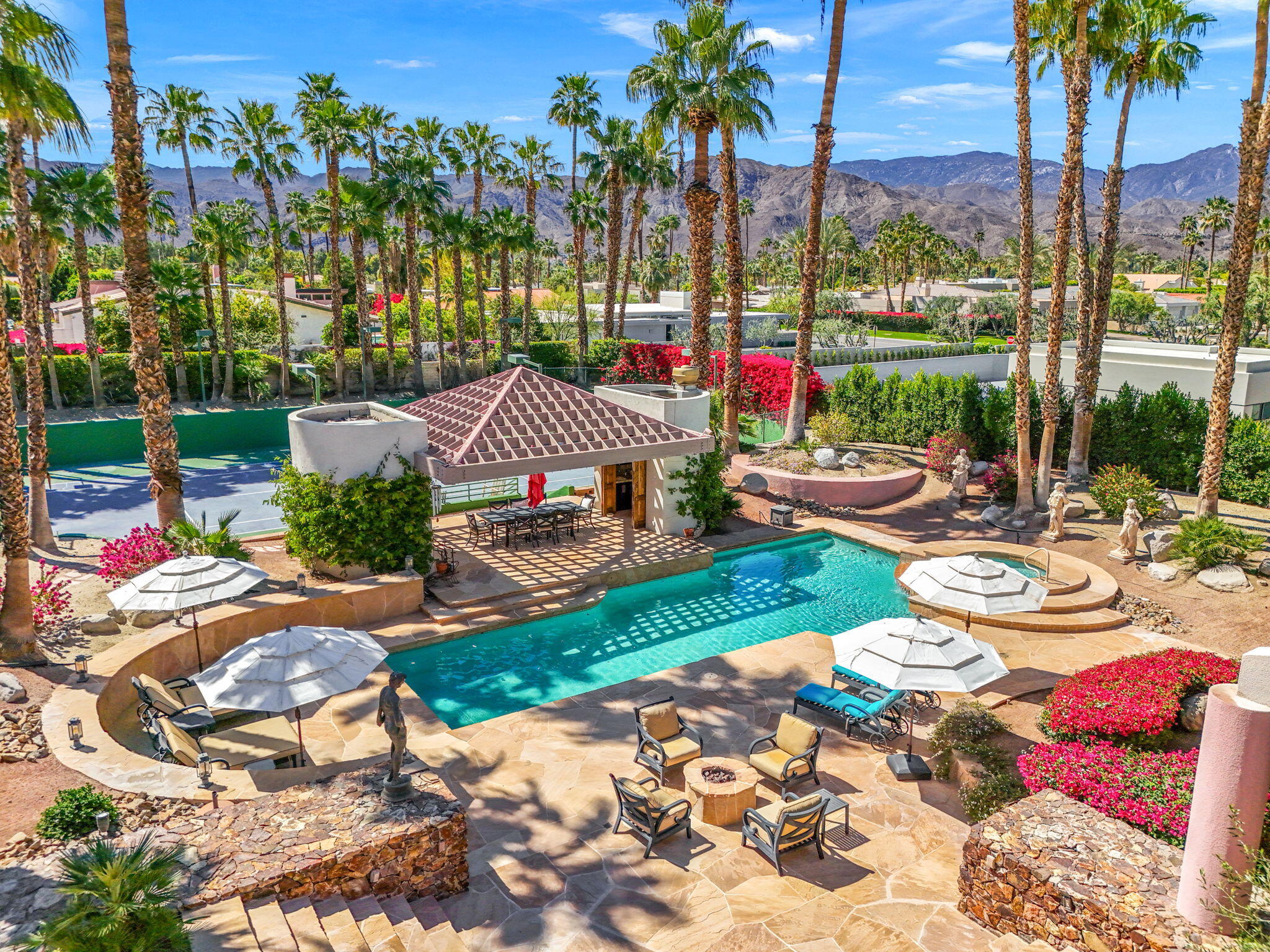 a view of a patio with table and chairs potted plants and palm trees