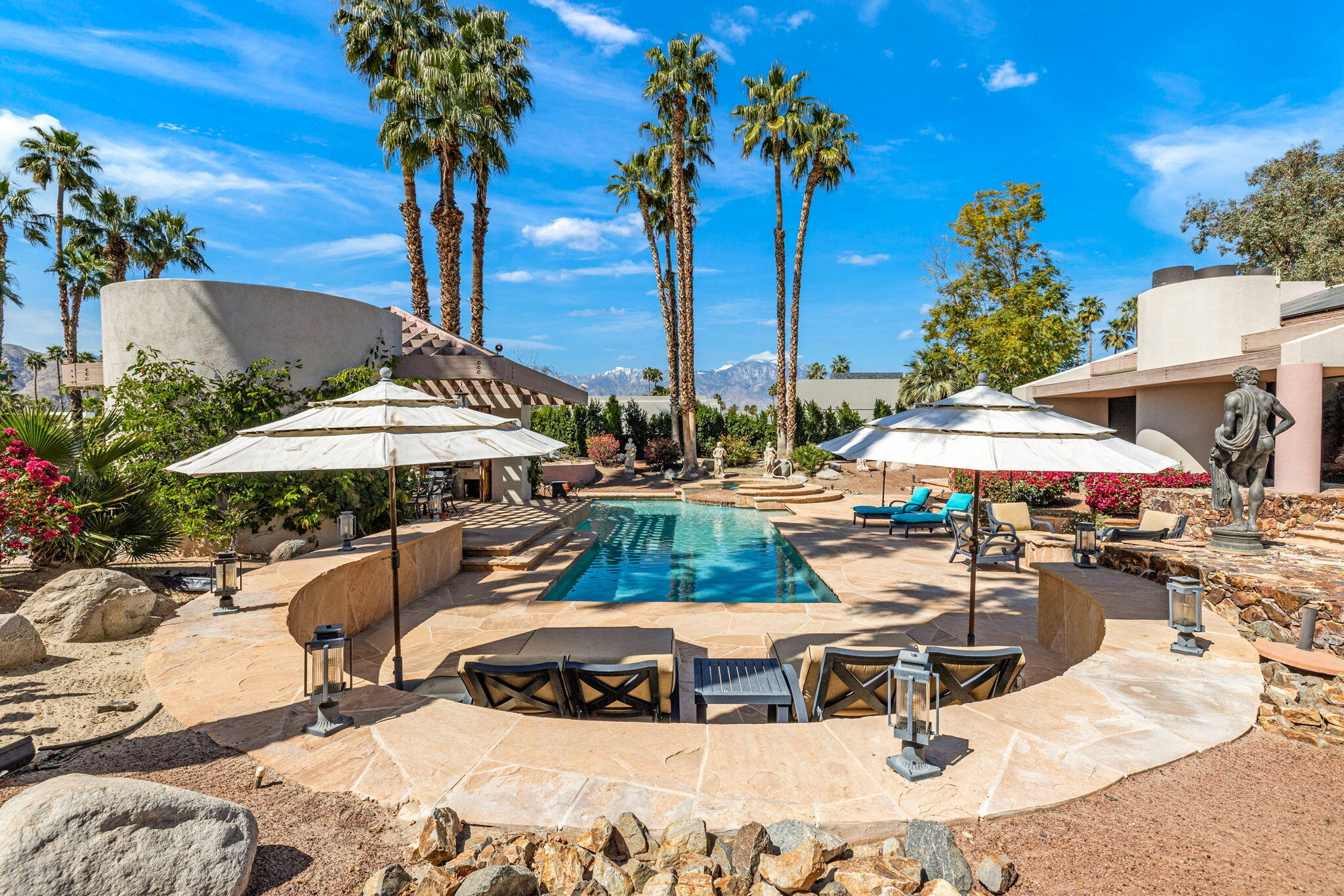 7 Big Sioux Road Rancho Mirage, CA 92270 - Photo 48 of 64 a view of a swimming pool with lawn chairs under an umbrella