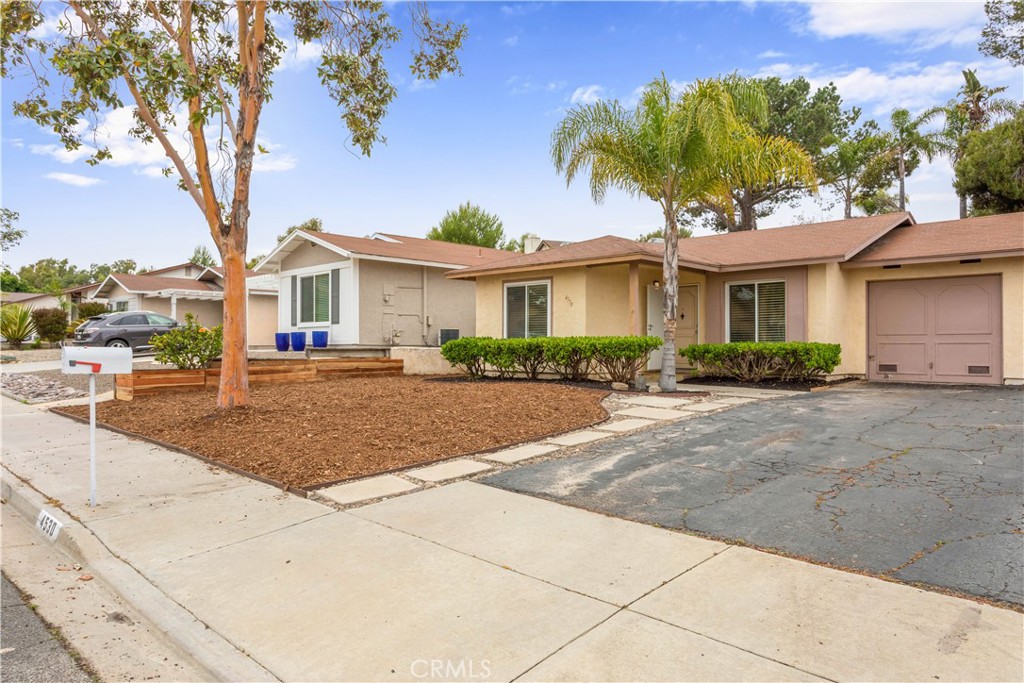 a front view of a house with a yard and trees