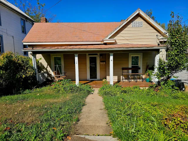 a view of a house with yard and porch