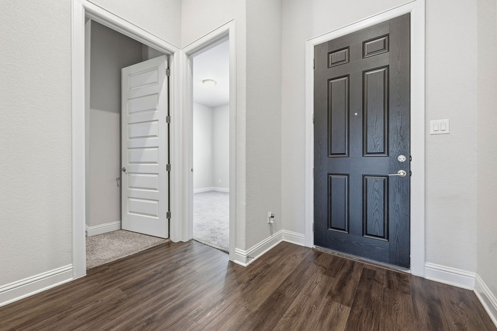 2032 Base Burner Path Leander, TX 78641 - Photo 12 of 34 Entryway featuring wood-finish flooring, a paneled dark-stained door, and white trim