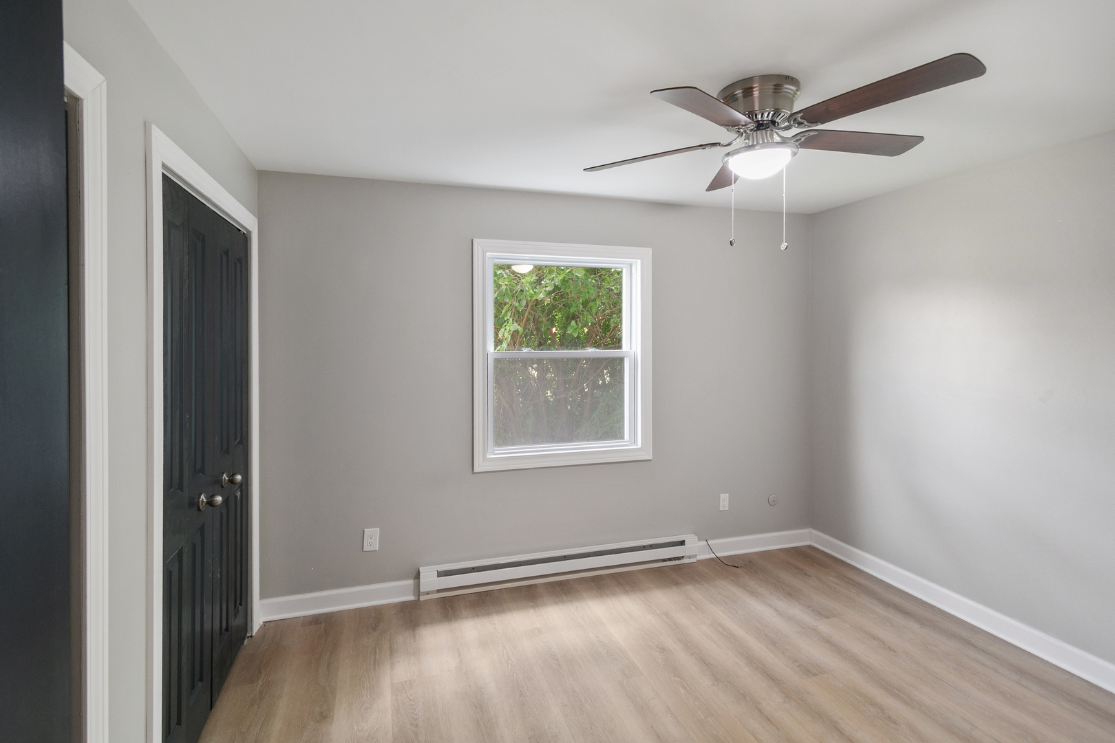 405 East Reed Street, Unit 9 Braidwood, IL 60408 - Photo 9 of 14 an empty room with wooden floor fan and windows